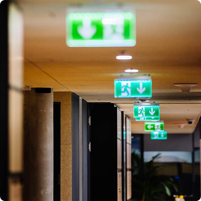 Emergency Lighting emergency exit signs lit up in a hotel corridor