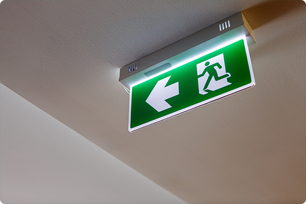 Integrated LED emergency exit sign in a hotel corridor ensuring safe egress.
